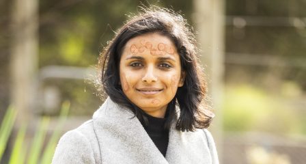 A Nepali scholar, Kamana Adhikari, is pictured with her face daubed with ochre