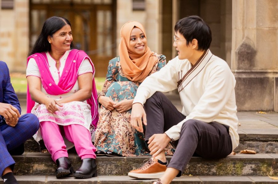 Three Australia Awards scholars talking on university steps