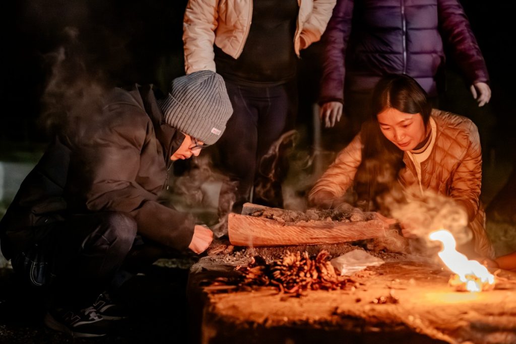 Oyuntugs (right) tries her hand at making fire alongside Bangladeshi scholar Aki Mittra Chakma (left).